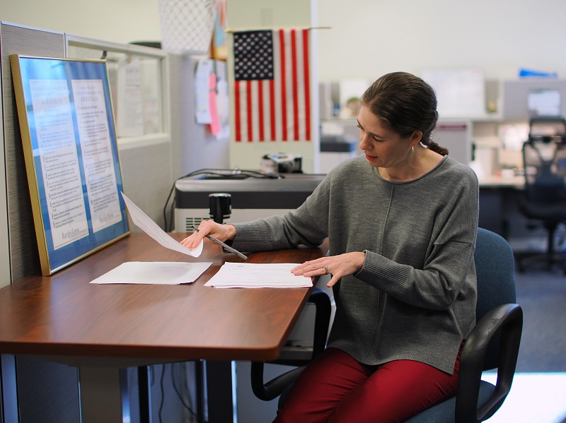 A picture of Deva Marie Proto, Sonoma County Clerk-Recorder-Assessor-Registrar of Voters, signing a stack of papers to certify the November 5, 2024, General Election